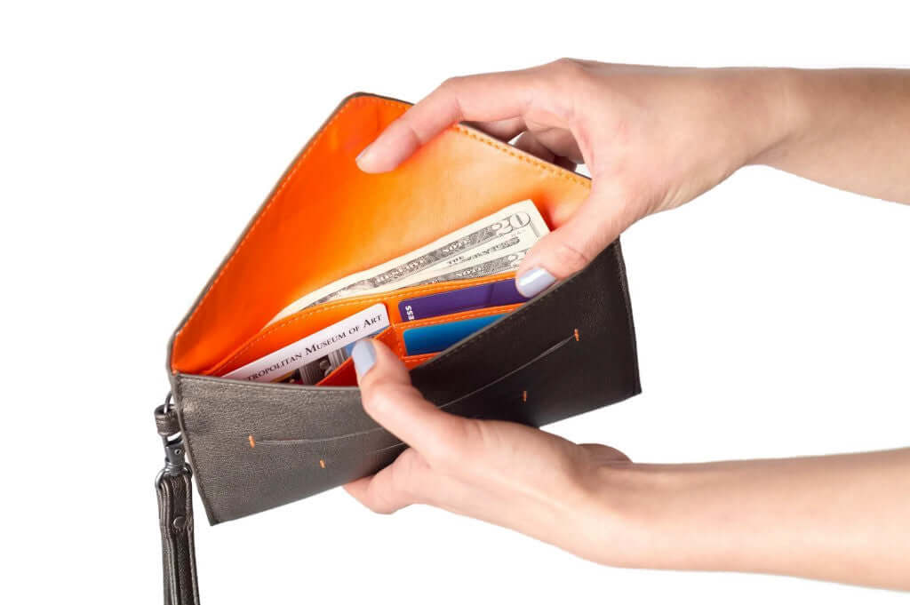 Person holding an open Delancey Vegan Wallet showing ample storage for bills and cards in fashionable, supple vegan leather.